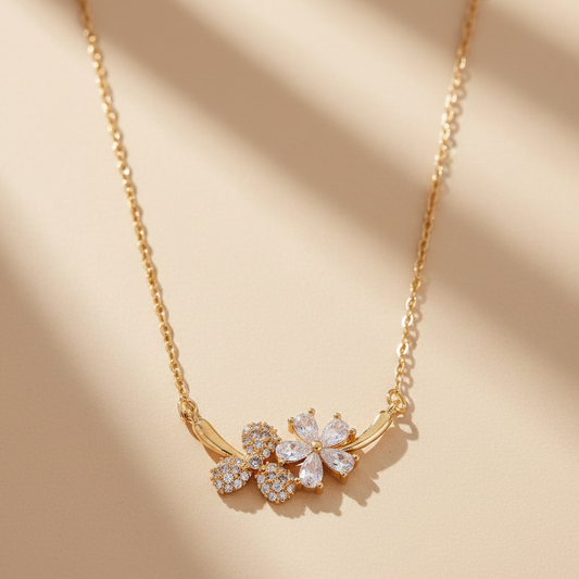 Gold necklace with floral pendant on a beige background